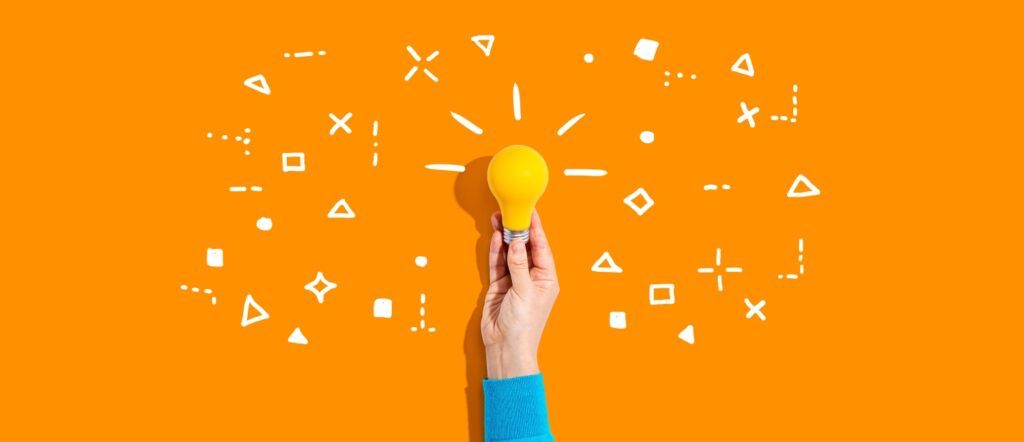 オレンジ色の背景、明るく輝く電球